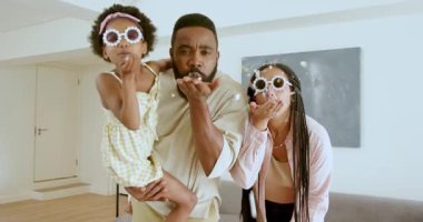 Çeşitli aileler kızlarının oturma odasında okula hazırlanmasına yardım ediyor, heyecandan sırıtıyorlar. Aile, ebeveynlik, hazırlık, eğlence, ev, destek, birliktelik, yaşam tarzı