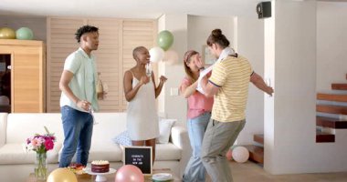 Arkadaşlar yeni işini pasta ve balonlarla kutluyor, mutlu bir şekilde gülümsüyor. Kutlama, arkadaşlık, mutluluk, parti, başarı, tebrikler