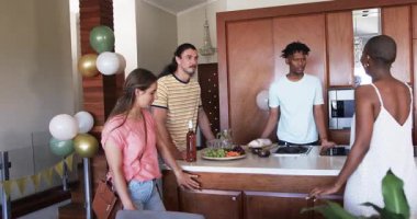 Arkadaşlar parti için balonlarla oturma odasını dekore ediyor, festival atmosferinin tadını çıkarıyorlar. Kutlama, dekorasyon, arkadaşlık, toplanma, eğlence, etkinlik