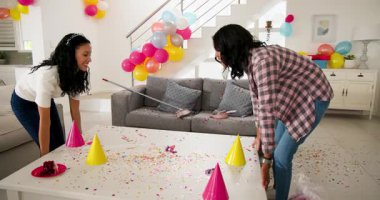 Doğum günü partisinden sonra çeşitli bayan arkadaşlar evde süpürge ve faraş temizleme konfetisi kullanıyorlar. Kutlama, dostluk, takım çalışması, neşeli, enerjik, rahat, işbirlikçi