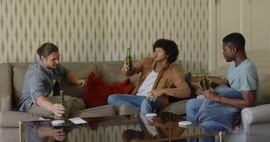 Çeşitli erkek arkadaşlar sehpada oturup bira şişelerini açacaklarıyla kapıyor, kadeh kaldırıyor, gülüyor. Gündelik, sosyalleşme, yoldaşlık, rahatlama, rahatlama, sıcaklık, arkadaşlık.