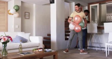 Partide, Arkadaşlar evde pasta ve süslemelerle doğum günü kutlaması hazırlıyorlar. parti, dostluk, kapalı alan, mutluluk, birleşme, yaşam tarzı