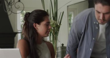 Ortak olarak yemek masasında dizüstü bilgisayarlar üzerinde işbirliği yapan çift omuzlarının üzerinden içeri giriyor. Romantik, samimi, samimi, yaşam tarzı, ev, işbirliği, sıcak