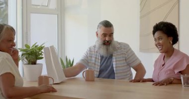 Üst düzey bir kadın hediye çantasına yaklaşıyor ve ultrason baskısı tulumlarını ortaya çıkarıyor. Aile, kutlama, jenerasyon, sürpriz, neşe, şefkat, sıcaklık