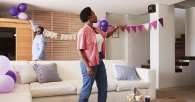 Afro-Amerikalı çift evde kutlama yapmak için oturma odasını dekore ediyor. birliktelik, aile, dekorasyon, mutluluk, olay, mevsim