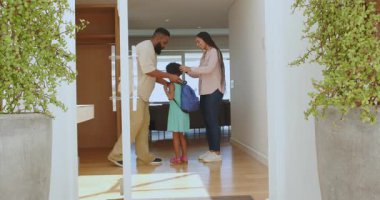 Siyah babanın kızını evde kucaklaması, mavi sırt çantasıyla okula hazırlanmasına yardım etmesi. Aile, bağlantı, eğitim, hazırlık, modern, ev, ebeveynlik, sıcaklık