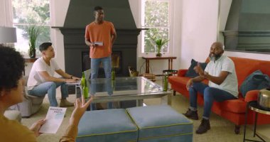 Bekarlığa veda partisini oturma odasında planlayan çeşitli erkek arkadaşlar, kağıt okuma, dizüstü bilgisayar yazma, gülme. İşbirliği, dostluk, sosyal, rahatlama, modern, yerli, gayri resmi