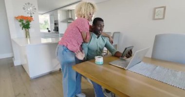 Video sohbetleri, evde dizüstü bilgisayar kullanırken gülümseyen çiftler, birlikte vakit geçirmenin tadını çıkarmak. Teknoloji, ilişki, mutluluk, bağlantı, oturma odası, boş zaman