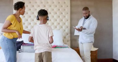 Aile bavullarını yatağa topluyor, tatile hazırlanıyor, seyahat planlarını evde tartışıyoruz. planlama, seyahat, boş zaman