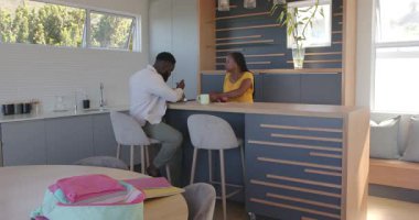 Afrika kökenli Amerikalı çift, modern ev adasında parlak parti malzemeleriyle sohbet ediyorlar. Kutlama, coşku, sohbet, toplanma, modern, rahat, dekor, mutluluk, arkadaşlık