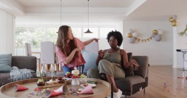 Afrikalı Amerikalı ve Asyalı arkadaşlar partiden sonra modern yaşam alanlarını temizliyor, konfeti temizliyorlar. Kutlama, düzenleme, arkadaşlık, modern, şenlikli, takım çalışması, temizlik, dekor