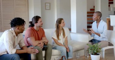 Partide, arkadaşlar evde tartışıyor, gülümsüyor ve tableti fikirler için kullanıyor. Beyin fırtınası, arkadaşlık, iletişim, teknoloji, yenilik, kapalı alanlarda