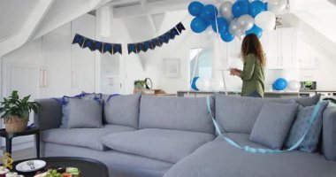 40 'lı yaşlarda bir kadın çatı katına giriyor, balonları ayarlıyor, parti için masaya şarap koyuyor, fotokopi çekiyor. Kutlama, zarafet, iç mekan, yaşam tarzı, şenlik, gündelik, dekor