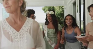 Bir arkadaşım terasta şişe açtıktan sonra, çeşitli kadınlar bekarlığa veda partisinde gelin kadeh kaldırıyor. Kutlama, arkadaşlık, açık hava, neşe, zarafet, kadınlık, lüks