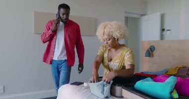 Çeşitli çiftler evde bavullarını topluyor, tatil gezisine hazırlanıyorlar. Seyahat, turizm, bagaj, planlama, hazırlık, varış yeri