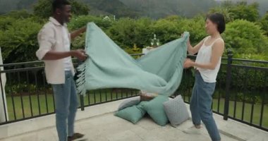 Hasır sepeti gören çeşitli çiftler, balkona yastık istiflemek için mercan atımı yapıyorlar. Samimiyet, işbirliği, açık havada yaşam, dokuma, yaşam tarzı, uyum, rahatlık