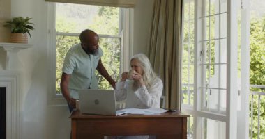 Masada evrakları düzenleyen, kahve fırlatan, sarılan kağıtları düzenleyen yaşlı çiftler. Takım çalışması, işbirliği, üretkenlik, başarı, bağlantı, sıcak, modern