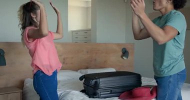 Genç çift yataklarına bavullarını topluyor, evde tatil macerasına hazırlanıyorlar. Seyahat, bagaj, tatil, hazırlık, yolculuk, kaçış