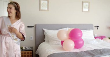 Çeşitli arkadaşlar modern otel odasına geliyor, balonlarla mutlu bir şekilde dans ediyor ve alkışlıyorlar. Kutlama, sevinç, seyahat, arkadaşlık, modern, canlı, konfor, heyecan, birliktelik