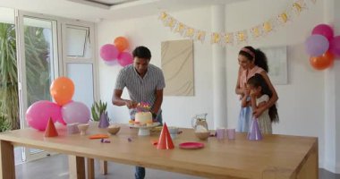 Çok ırklı aile kapalı partilerde yeni bir başlangıcı kutluyor, saç şekillendiriyor ve beyaz pasta kesiyor. Kutlama, aile, birliktelik, neşe, mutluluk, şenlik, parti, bağ