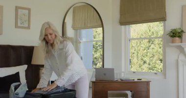 Üst düzey çift, rujlarını hatırladıktan sonra bavullarını hazırlarken güneş gözlüğü takıyor. Çift, valiz, seyahat, yaşam tarzı, iç mekan, rahat, dinlendirici