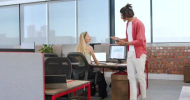 Ofiste pencere kenarındaki tartışmalara katılan çeşitli iş arkadaşları tablet ve belgeleri sıkıca tutuyorlar. İşbirliği, üretkenlik, modern, çalışma alanı, bağlılık, takım çalışması, doğal ışık