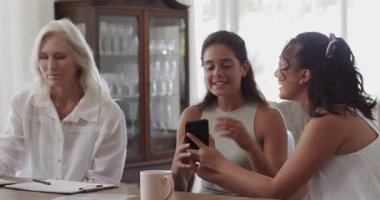 Çeşitli bayan meslektaşlar yemek masasındaki akıllı telefon, dizüstü bilgisayarı inceliyor ve işbirliği yapıyorlar. İşbirliği, takım, tartışma, yenilik, parlaklık, çoklu görev, profesyonel