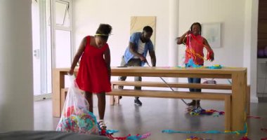 Afro-Amerikalı aile parti dekorasyonunu düzenliyor, plastik poşetleri flama ile temizliyor. Kutlama, aile, temizlik, balonlar, renkli, ev, şenlikler, takım çalışması