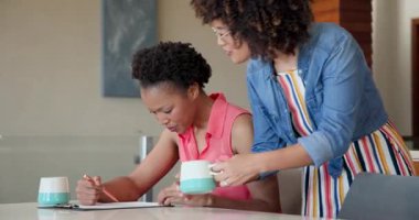 Evrakları kahve içerken tartışıyorlar, Afro-Amerikan lezbiyen çift evde sohbet ediyorlar. tartışma, arkadaşlık, gündelik, toplantı, yaşam tarzı, işbirliği