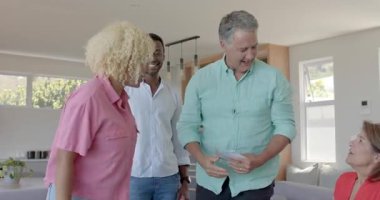 Çeşitli aileler ailelerini ziyaret eder, birbirlerine sarılırlar, hediye paketini açarlar, oturma odasında sohbet ederler. Aile, birleşme, bağlantı, sıcaklık, kutlama, modern, samimi