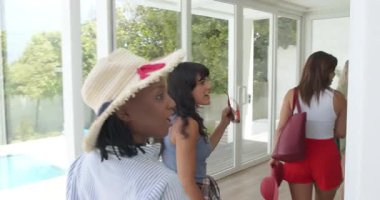 Çeşitli arkadaşlar tatil için verandaya geliyorlar, çantalar taşıyorlar ve gülümsüyorlar. Tatil, arkadaşlık, heyecan, modern, açık hava, seyahat, varış, eğlence