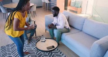 Afro-Amerikalı bir adam dinlenme odasında notları tartışırken ve suyu paylaşırken çifte danışmanlık yapıyor. İşbirliği, tartışma, takım çalışması, modern, sosyal, profesyonel, katılım