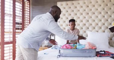 Baba ve oğul bavullarını hazırlıyor, aile tatiline hazırlanıyorlar, evde. Seyahat, bağ, bagaj, varış, macera, hazırlık