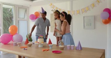 Çeşitli aileler evde doğum günü partisi veriyor, süslü pasta ve renkli parti şapkalarının tadını çıkarıyorlar. Kutlama, neşe, dekorasyon, toplanma, mutluluk, olay, eğlence, şenlik