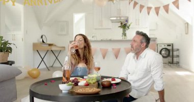 Son sınıf çifti yıldönümü afişini fark ediyor, yıldönümünü kutlarken mutfakta dans ediyor. Aşk, kutlama, samimiyet, dekor, neşe, yaşam tarzı, samimiyet