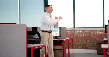 Modern ofis ortamında dans eden çeşitli iş arkadaşları masalarla ve bilgisayarlarla neşeli bir sevinç paylaşıyorlar. Kutlama, takım çalışması, modern, iş yeri, neşe, coşku, ofis