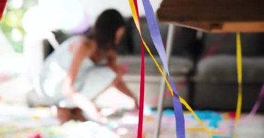 Partiden sonra çeşitli bayan arkadaşlar oturma odasında süpürge kullanarak flama ve konfeti paketliyor. Kutlama, dostluk, ev, dekor, canlı, rahat, neşeli