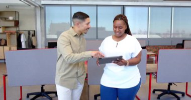 Modern ofiste tabletle uğraşan, gülümseyen ve fikirleri paylaşan çeşitli iş arkadaşları. Ofis, işbirliği, yenilik, teknoloji, takım çalışması, parlak, gündelik