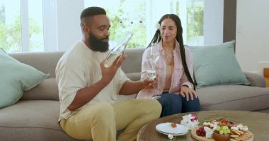 Çift, sıcak oturma odasındaki kanepede kutlama yapıyor şampanya kadehlerini kaldırıyor ve gülümsüyor. Kutlama, samimiyet, romantizm, tost, neşe, konfor, beraberlik, dekor, mutluluk