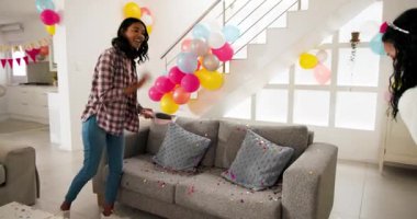 Çeşitli bayan arkadaşların konfeti fırçalaması, kanepeyi değiştirmesi, doğum gününden sonra kahve masasını silmesi. Kutlama, takım çalışması, yerli, neşeli, enerjik, işbirliği, yaşam tarzı