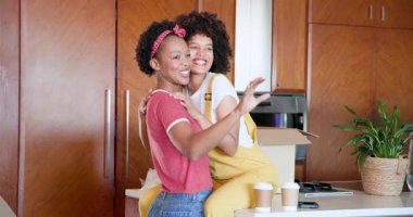 Mutfakta kucaklaşan mutlu lezbiyen çift kahve ve kahkahaların keyfini çıkarıyorlar. Mutluluk, bağlanma, ilişki, aile içi, yaşam tarzı, sabah