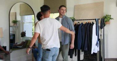 Erkek terzi, takım elbise için yatak odasında kollarını kaldırdıktan sonra bir mezura ile müşterinin gövdesini ölçüyor. Terzilik, moda, ölçü, gardırop, tarz, giysi