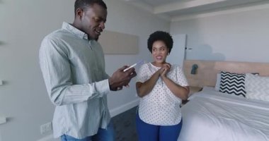 Çeşitli çiftler yatakta dinleniyor, evde birlikte akıllı telefonlara bakarken gülümsüyorlar. Rahatlama, teknoloji, ev hayatı, birliktelik, bağlanma, rahatlama