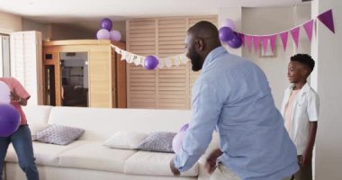 Balonlar ve afişlerle dekore edilen oturma odası, mutlu bir şekilde doğum gününü evde kutlayan çift. Kutlama, parti, mutluluk, şenlik, ev, dekorasyon