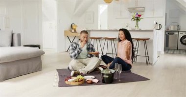 Afro-Amerikalı çift evde peynir tadıp bardaklarını tokuşturarak yıldönümlerini kutluyor. Romantizm, kutlama, yakınlık, boş zaman, açık hava, yaşam tarzı, neşeli