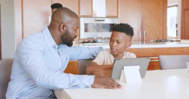 Anne yakınlarda telefonla konuşurken baba oğluna tablet konusunda yardım ediyor. Ebeveynlik, aile, teknoloji, çoklu görev, dijital aygıt, iletişim