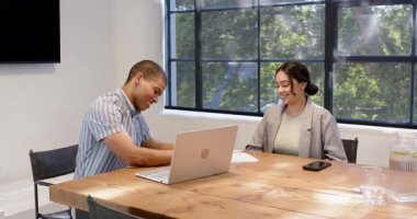 Mutlu iş arkadaşları kağıtları imzalıyor, el sıkışıyor, ofiste dizüstü bilgisayar kullanıyor. Toplantı, iş, iş, ofis çalışma ortamı kavramı.