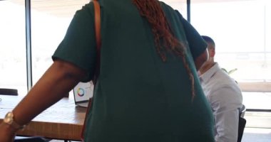 Modern ofisin ahşap masasında oturan çeşitli çiftler doğal ışık ve yeşil bitkilerle. Çift, etkileşim, modern, gündelik, yeşillik, iletişim, ışık