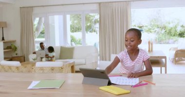 Afro-Amerikan anne-kız tabletlerle uğraşıyorlar, kağıt ve kalemlerle. Etkileşim, yaratıcılık, öğrenme, ev, aile, işbirliği, parlak, modern, neşeli