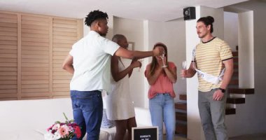 Arkadaşlar evde şampanyayla kutlama yapıyor, gülümsüyor ve anın tadını çıkarıyorlar. Kutlama, parti, arkadaşlık, tost, içecek, şerefe